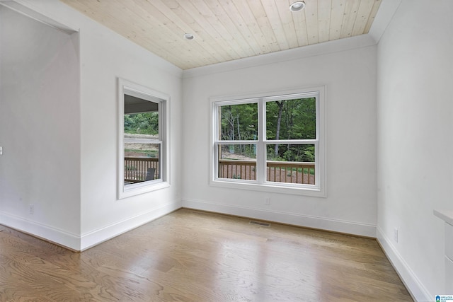 unfurnished room featuring baseboards, light wood finished floors, visible vents, and wood ceiling
