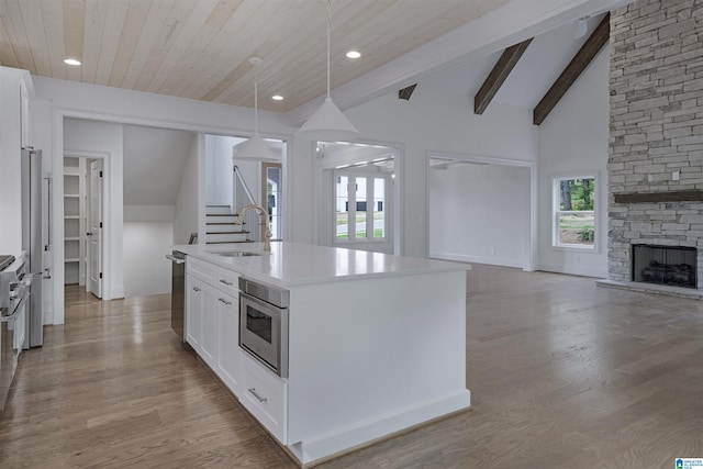 kitchen with plenty of natural light, a sink, white cabinetry, and open floor plan