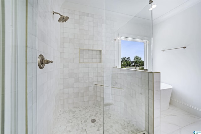 bathroom with a freestanding tub, a shower stall, and baseboards