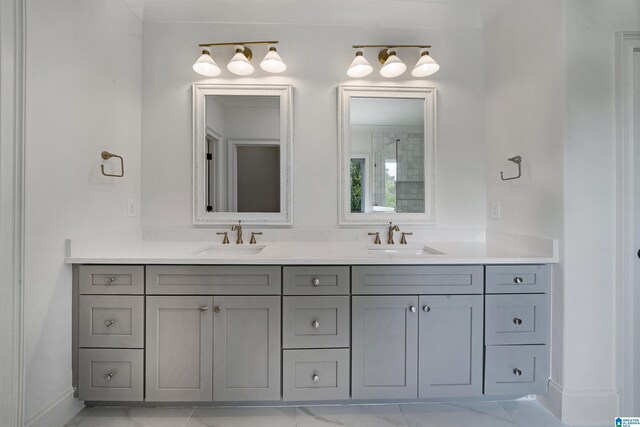 bathroom featuring baseboards, a sink, and double vanity