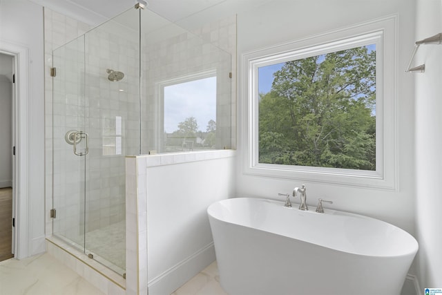 full bathroom with a freestanding tub, a stall shower, marble finish floor, and a wealth of natural light