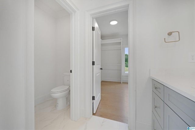 bathroom with baseboards, vanity, and toilet