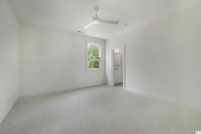 spare room featuring visible vents, baseboards, ceiling fan, and light carpet