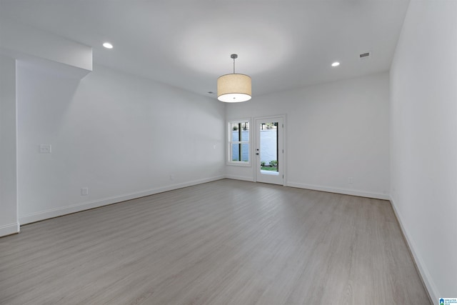 spare room with baseboards, recessed lighting, and light wood-style flooring