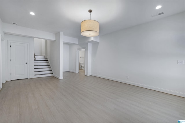 unfurnished living room with light wood finished floors, stairs, recessed lighting, baseboards, and visible vents