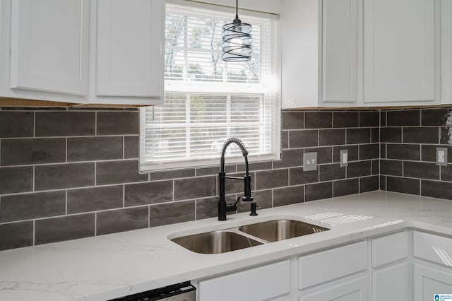 kitchen with sink, white cabinets, decorative backsplash, and pendant lighting