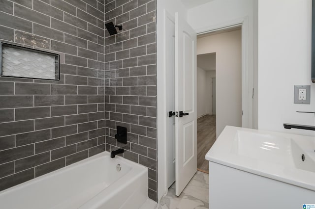 bathroom featuring vanity and tiled shower / bath