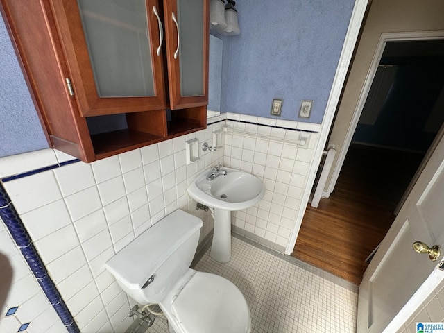 bathroom featuring tile walls, toilet, and tile patterned flooring