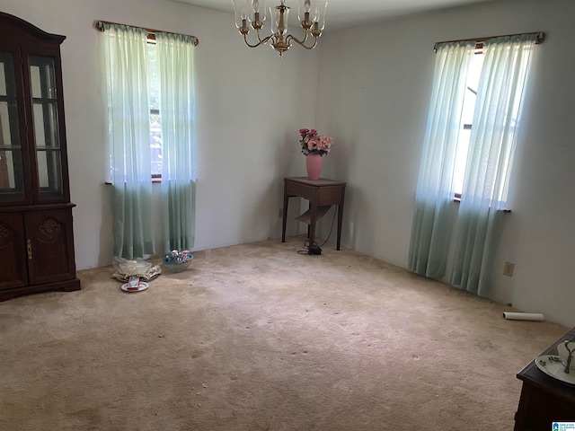 carpeted spare room featuring a notable chandelier