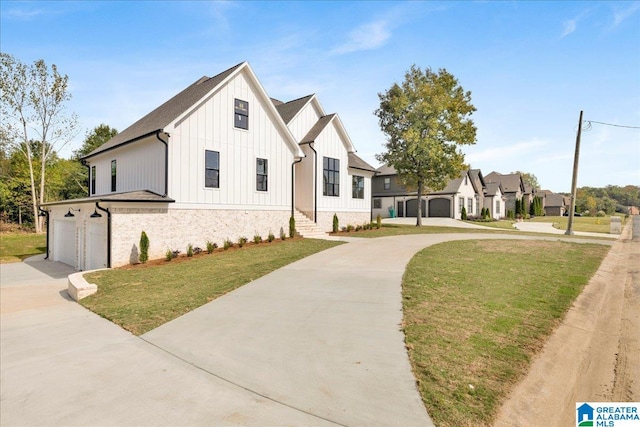 modern inspired farmhouse featuring a front lawn and a garage