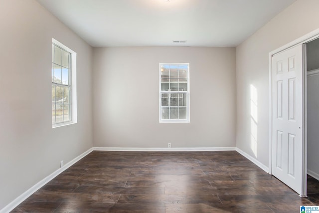 unfurnished bedroom featuring dark wood-type flooring and a closet