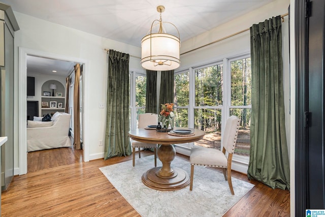 dining area with built in features and hardwood / wood-style floors