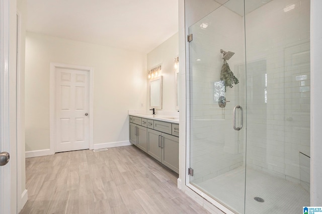 bathroom with vanity, wood-type flooring, and a shower with door