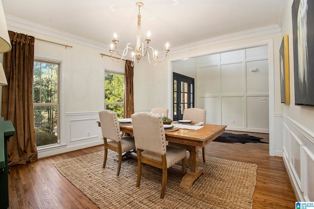 dining space with an inviting chandelier, ornamental molding, and hardwood / wood-style flooring