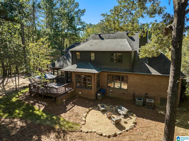 back of property featuring a patio, a deck, a fire pit, and central AC unit