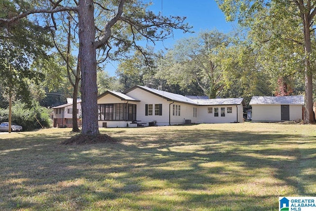 ranch-style house featuring a front lawn, central air condition unit, and a sunroom