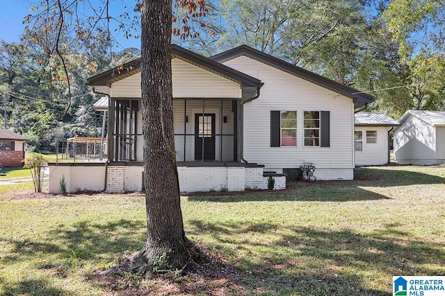 view of front of property with a front yard and a sunroom