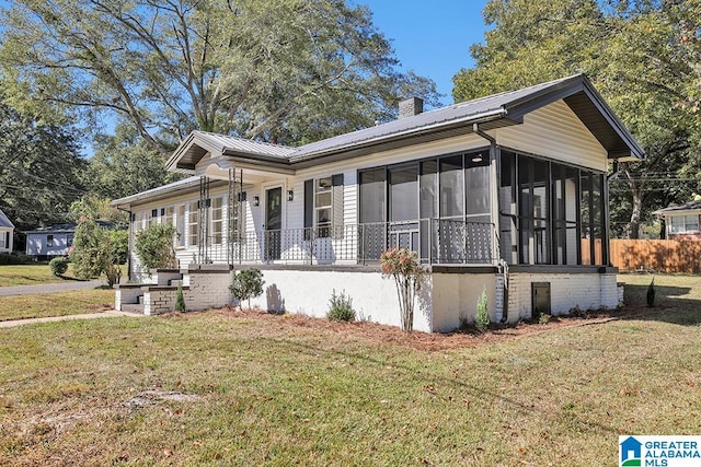 view of front of home with a sunroom and a front yard