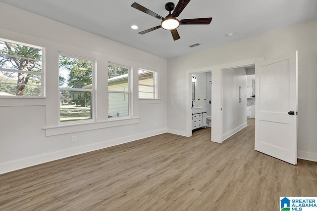 unfurnished bedroom with light hardwood / wood-style flooring, ensuite bath, and ceiling fan