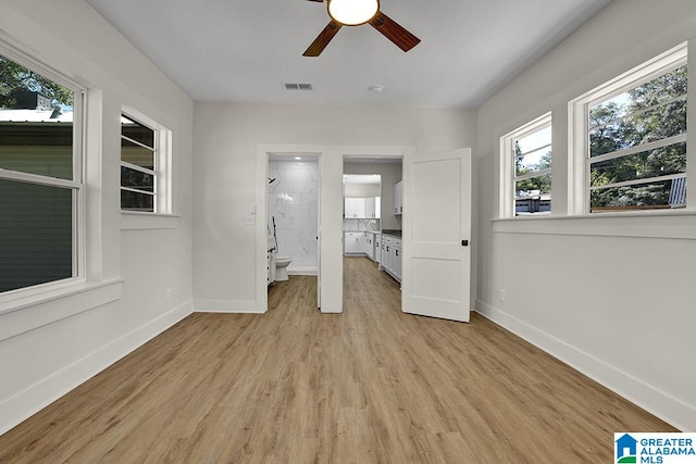 unfurnished bedroom with light hardwood / wood-style flooring, ensuite bathroom, and ceiling fan