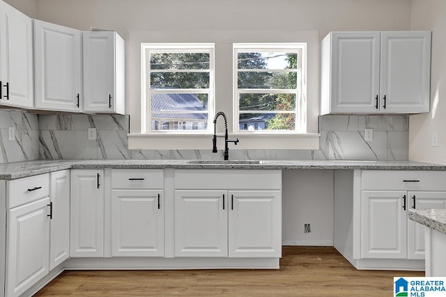 kitchen with sink, white cabinetry, and light hardwood / wood-style floors