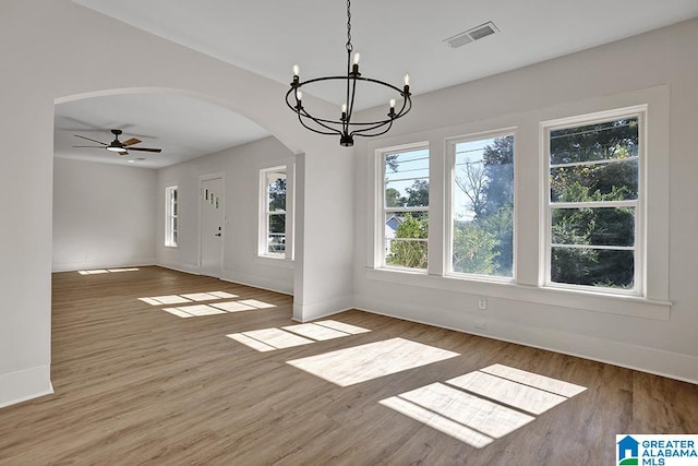 unfurnished dining area featuring hardwood / wood-style floors and ceiling fan with notable chandelier