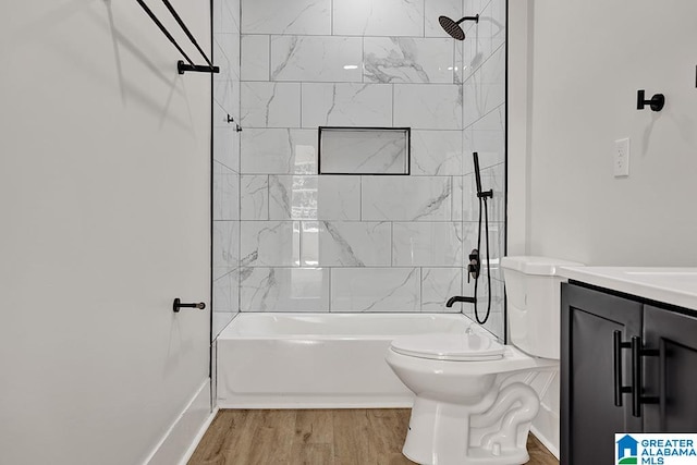 full bathroom featuring vanity, tiled shower / bath combo, wood-type flooring, and toilet