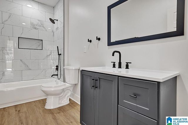 full bathroom with vanity, toilet, hardwood / wood-style flooring, and tiled shower / bath combo