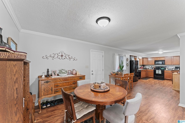 dining room featuring crown molding, wood-type flooring, and a textured ceiling