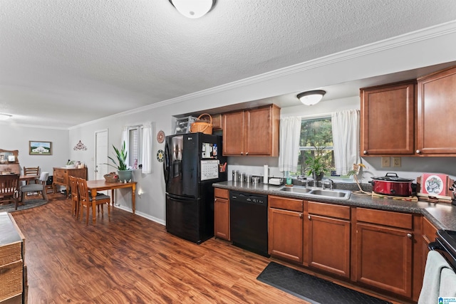 kitchen featuring hardwood / wood-style floors, a textured ceiling, ornamental molding, black appliances, and sink