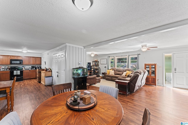 dining room featuring ceiling fan, a textured ceiling, dark hardwood / wood-style flooring, and ornamental molding