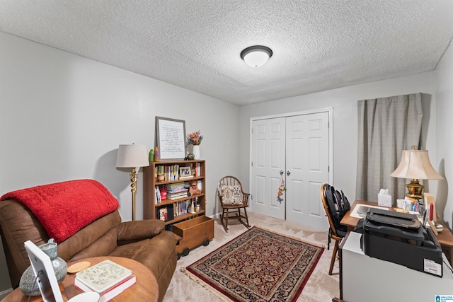 carpeted home office featuring a textured ceiling