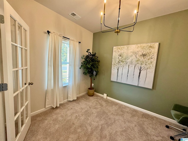 interior space with a chandelier, light colored carpet, and rail lighting