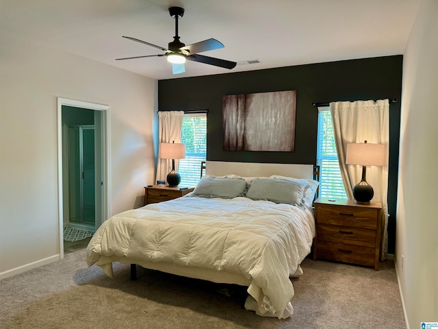 carpeted bedroom featuring ceiling fan and ensuite bathroom