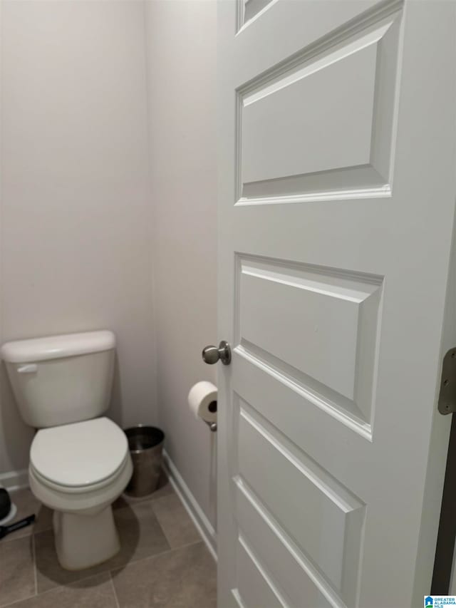 bathroom with toilet and tile patterned flooring