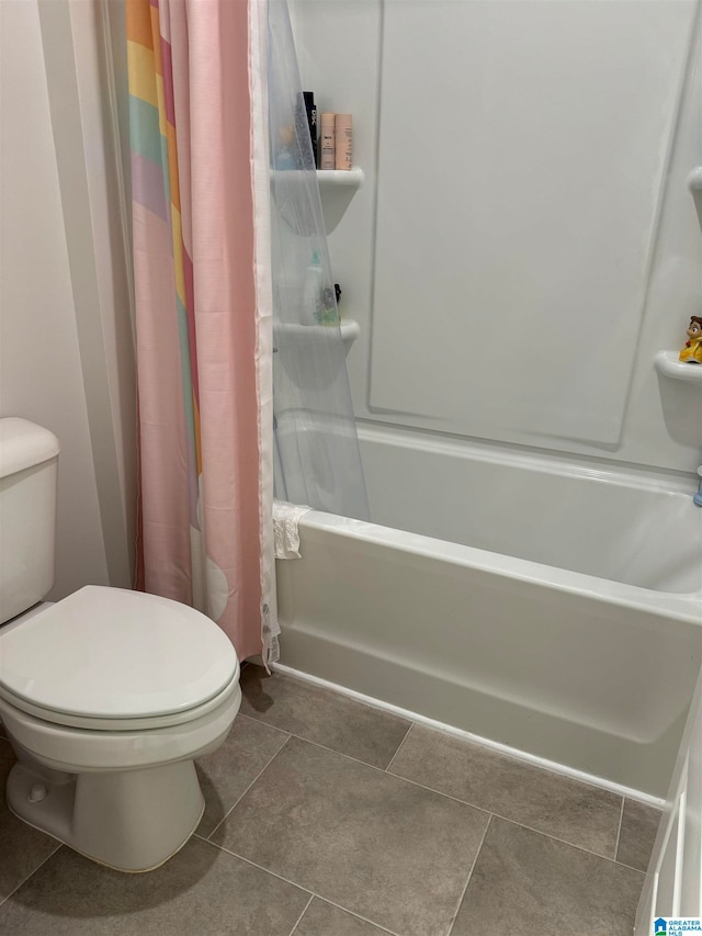 bathroom featuring toilet, shower / bath combination with curtain, and tile patterned flooring