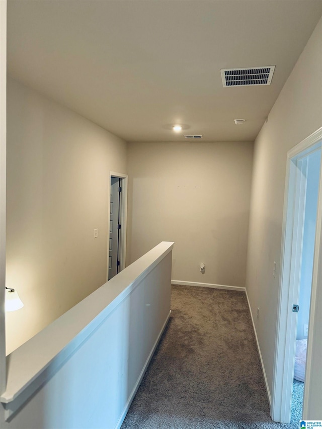 hallway featuring dark colored carpet