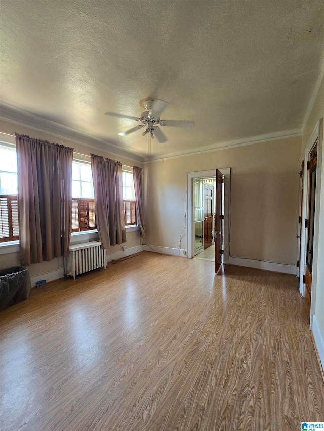 unfurnished room featuring radiator, light hardwood / wood-style flooring, crown molding, a textured ceiling, and ceiling fan