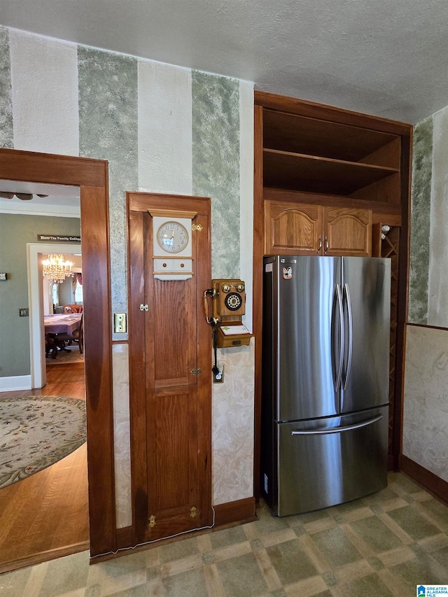 kitchen featuring stainless steel refrigerator and a textured ceiling