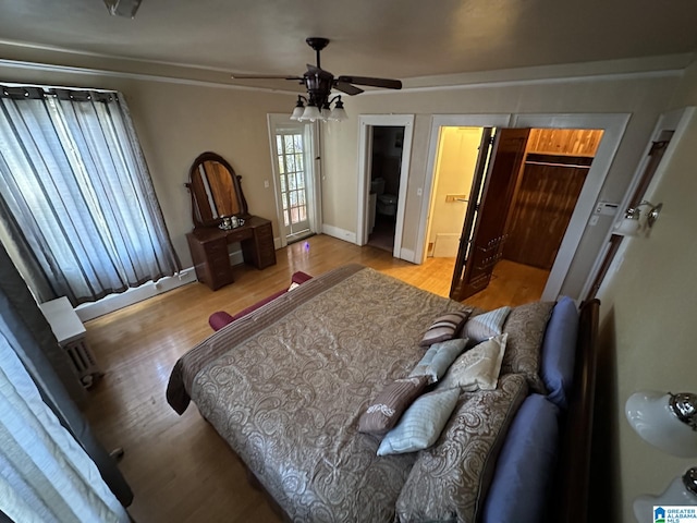 bedroom with a walk in closet, ceiling fan, connected bathroom, light hardwood / wood-style flooring, and a closet