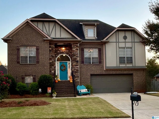 tudor-style house featuring a front yard and a garage