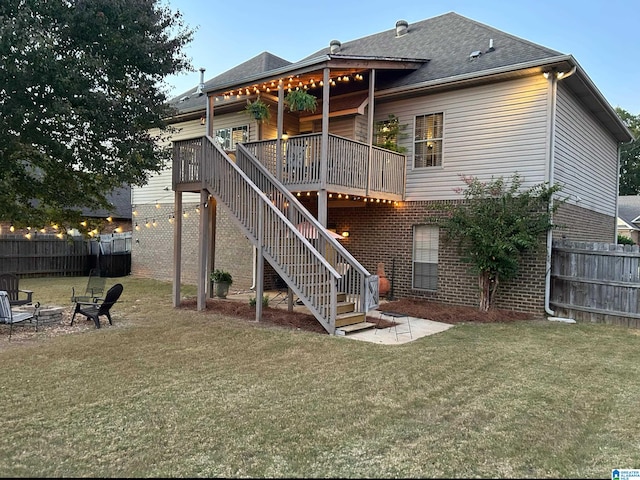 back of house with a wooden deck and a lawn