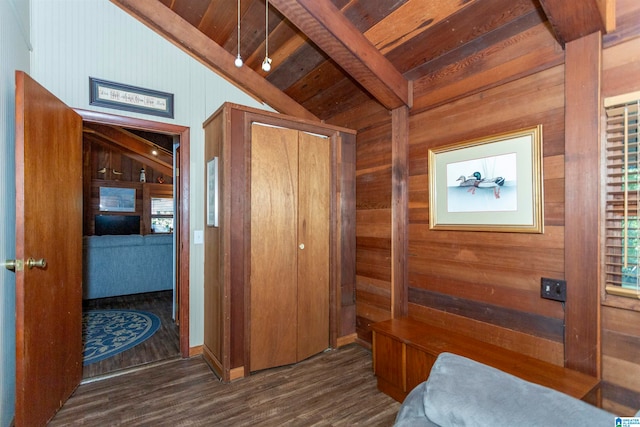 bedroom with dark hardwood / wood-style flooring, lofted ceiling with beams, wooden ceiling, and wood walls