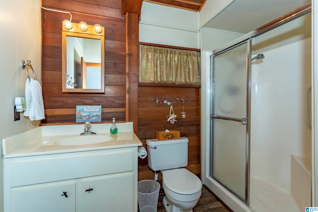 bathroom featuring hardwood / wood-style flooring, toilet, vanity, an enclosed shower, and wooden walls