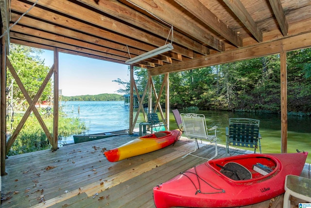 dock area featuring a deck with water view and a fire pit