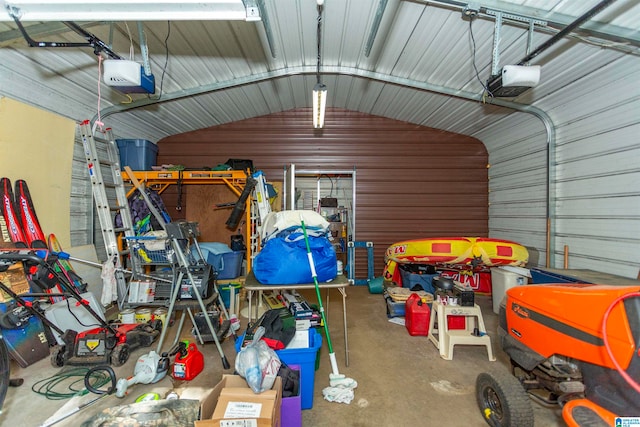 garage featuring a garage door opener and wooden walls