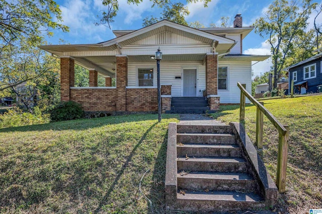 view of front of house featuring covered porch and a front lawn