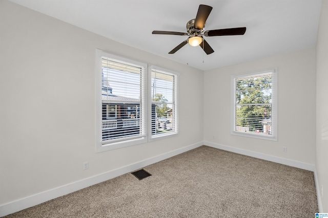 carpeted spare room featuring ceiling fan