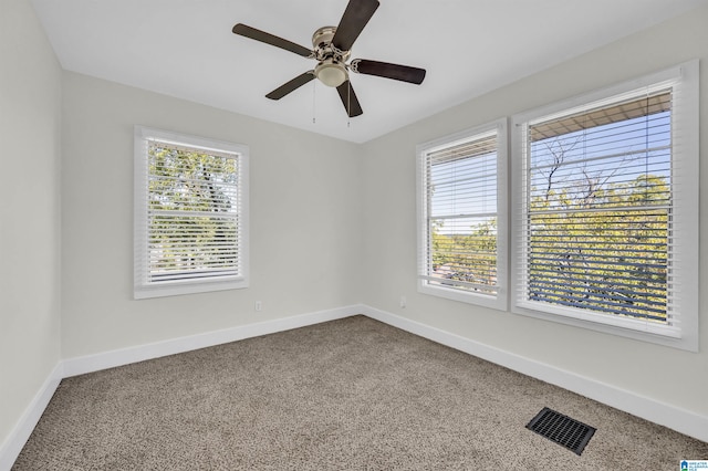 carpeted empty room featuring plenty of natural light and ceiling fan