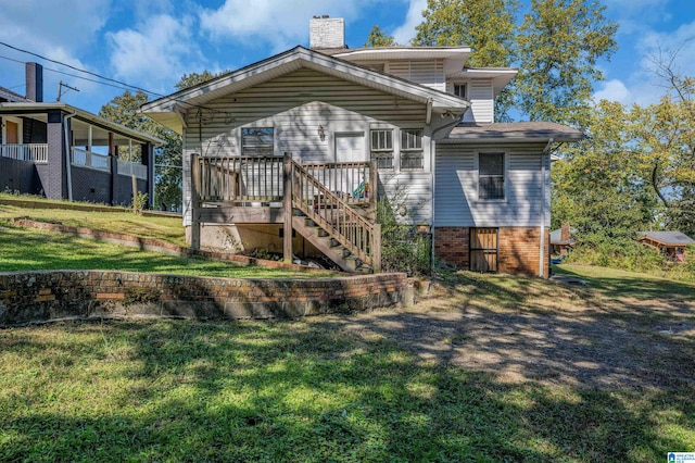 rear view of property featuring a yard and a deck